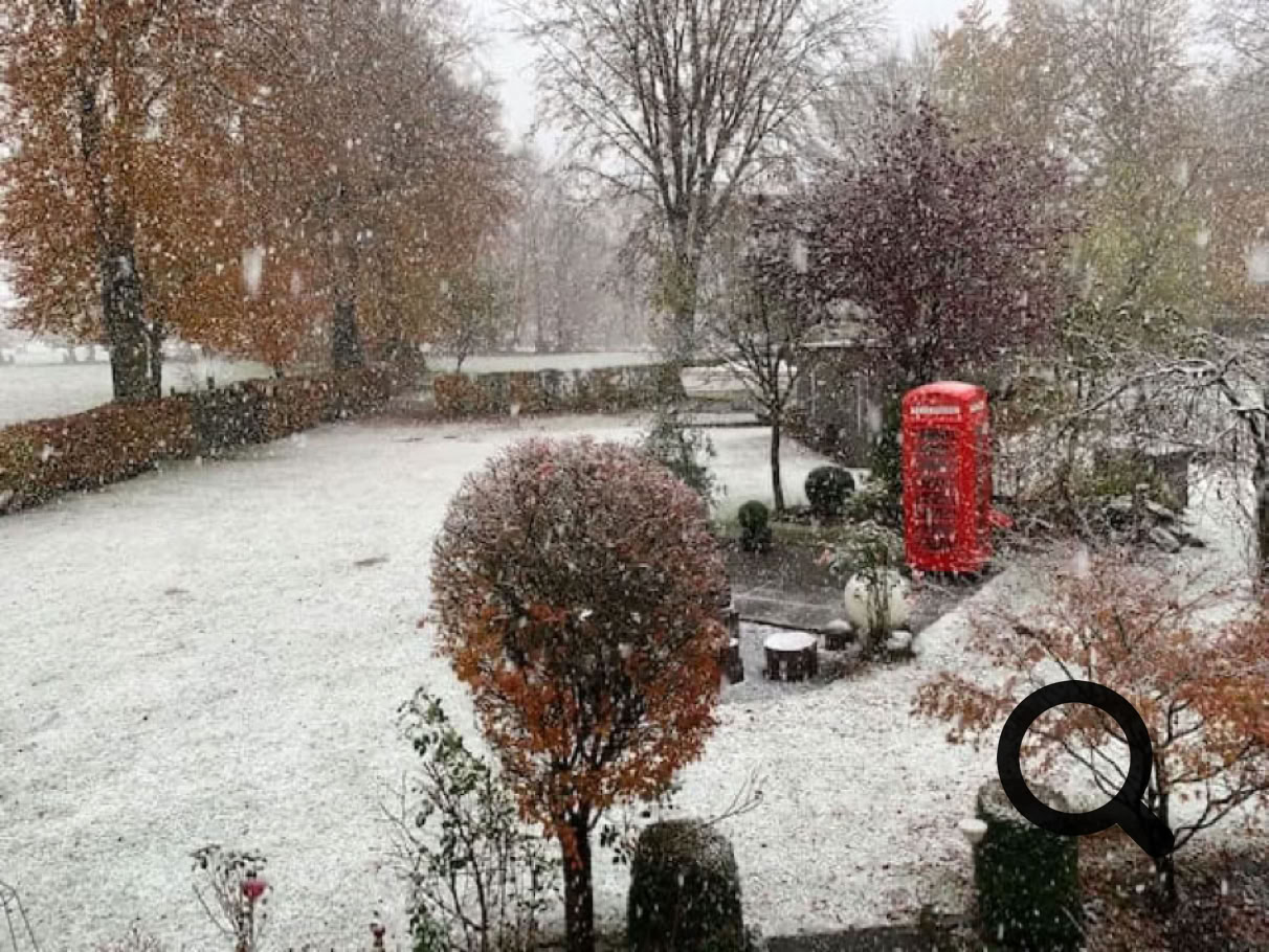Ein roter Telefonzelle Briefkasten steht im Schnee